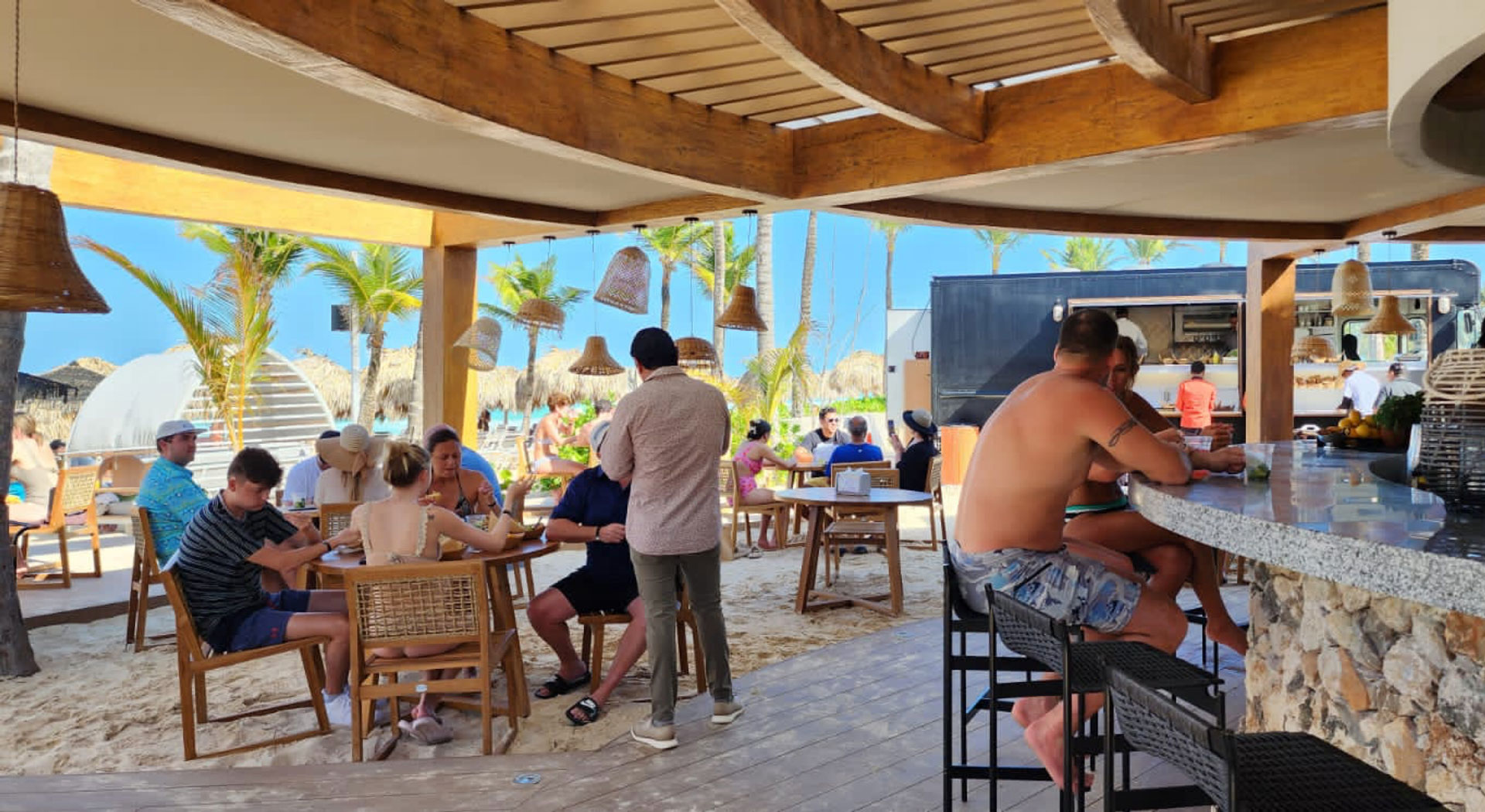 a group of people sitting at tables outside