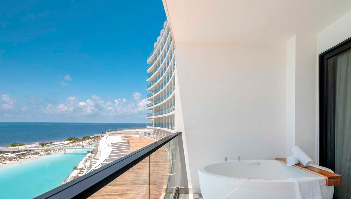 a balcony with a tub and a body of water