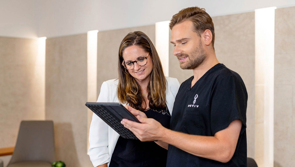 a man and woman looking at a tablet